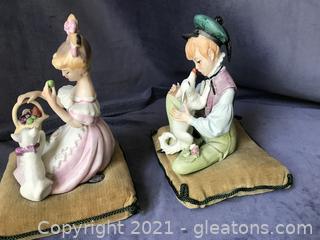 Vintage bisque boy and girl sitting on velvet pillows