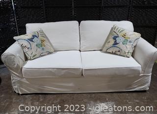 Slipcovered 2 cushion Sofa with Floral Throw Pillows