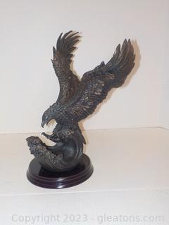 Majestic Statue of an Eagle Catching a Fish. On Wooden Base